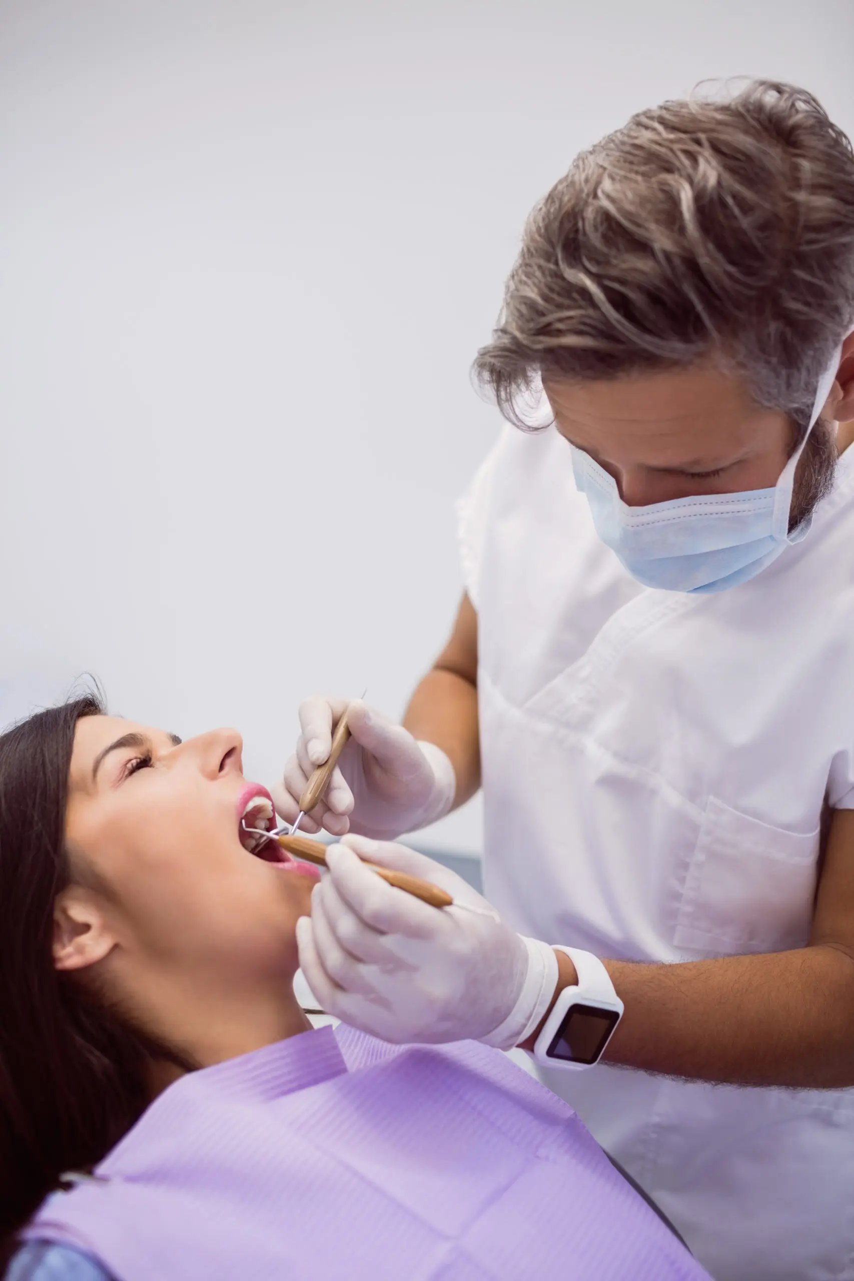 dentist examining female patient teeth in clinic